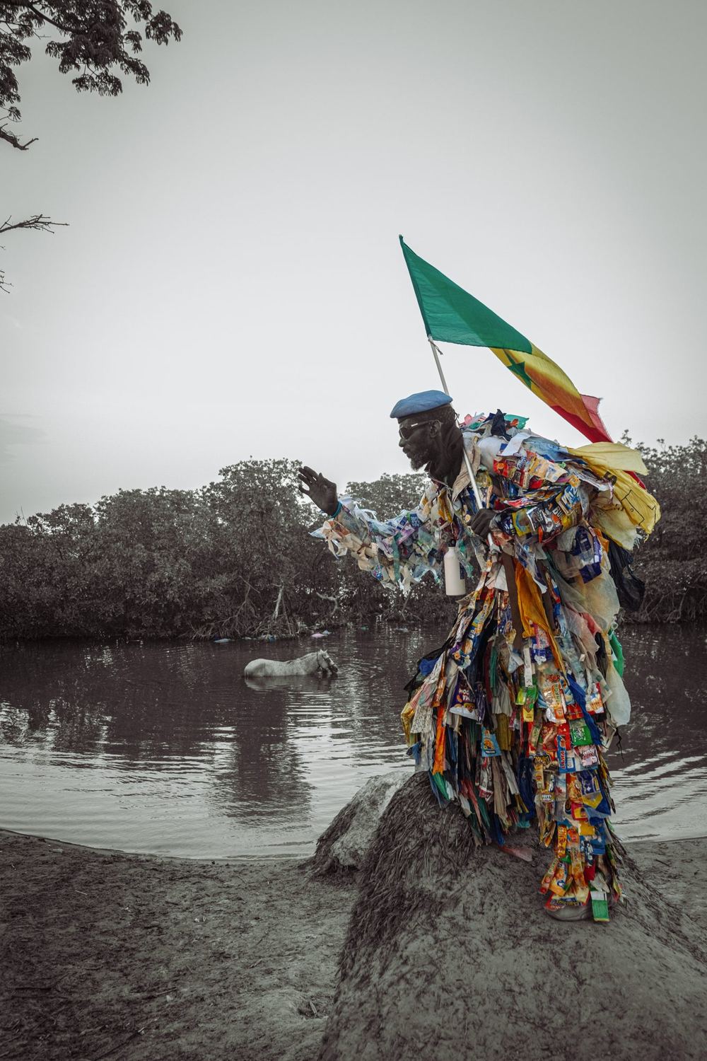 L’Homme Plastique reaches out towards a horse standing in a mangrove lagoon
